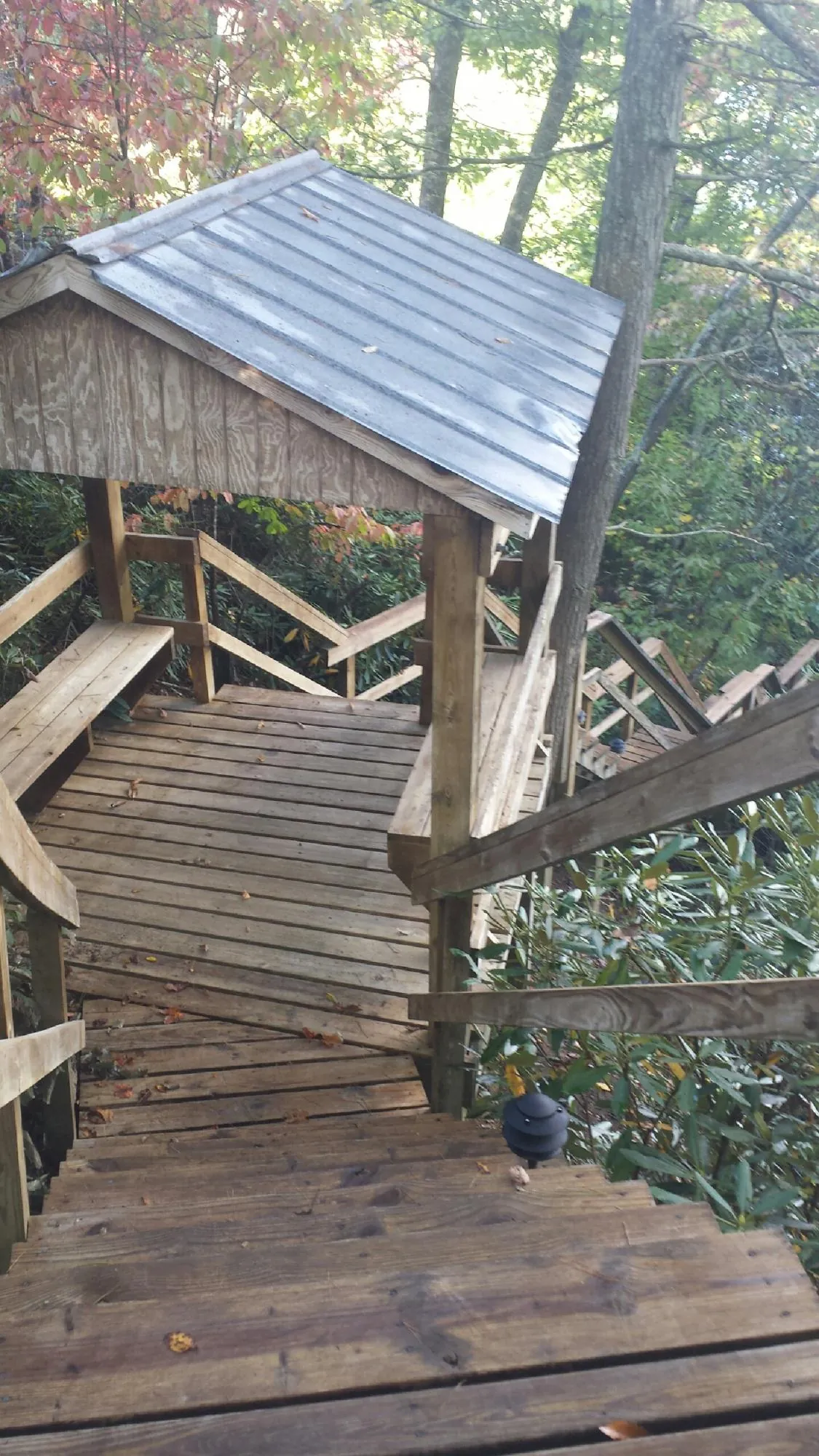 Metal roofed shelter over wooden steps on a wooded walkway — Skylight Repair & Installation work by our crew in Sullivan